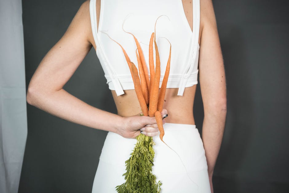 A person holding freshly harvested carrots.