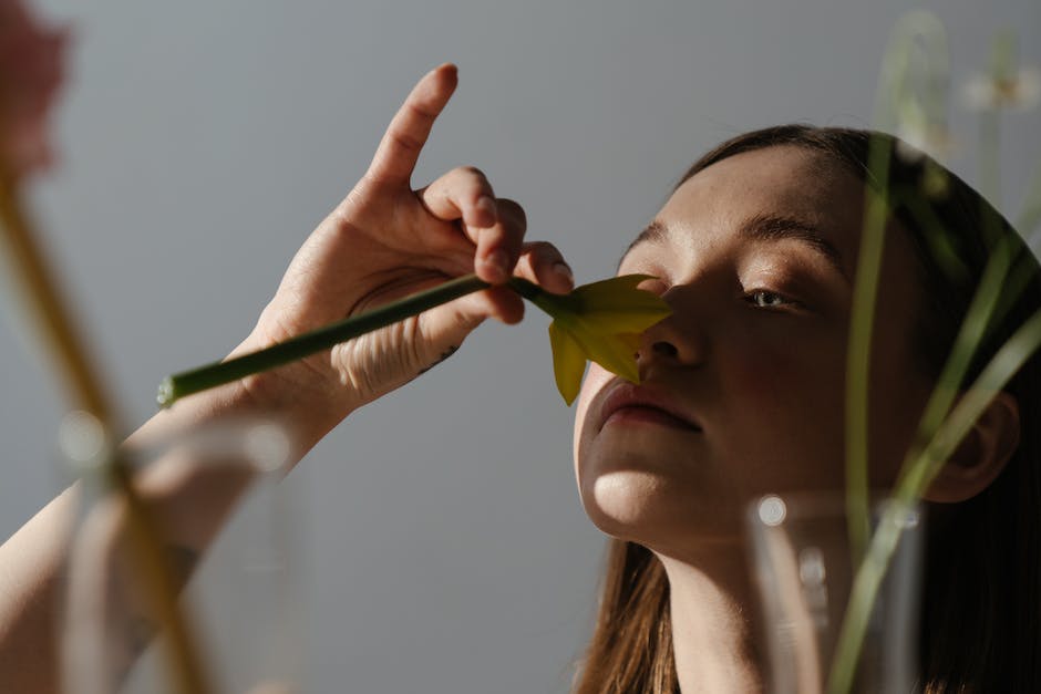 Close-up image of a gardener deadheading a daffodil flower.