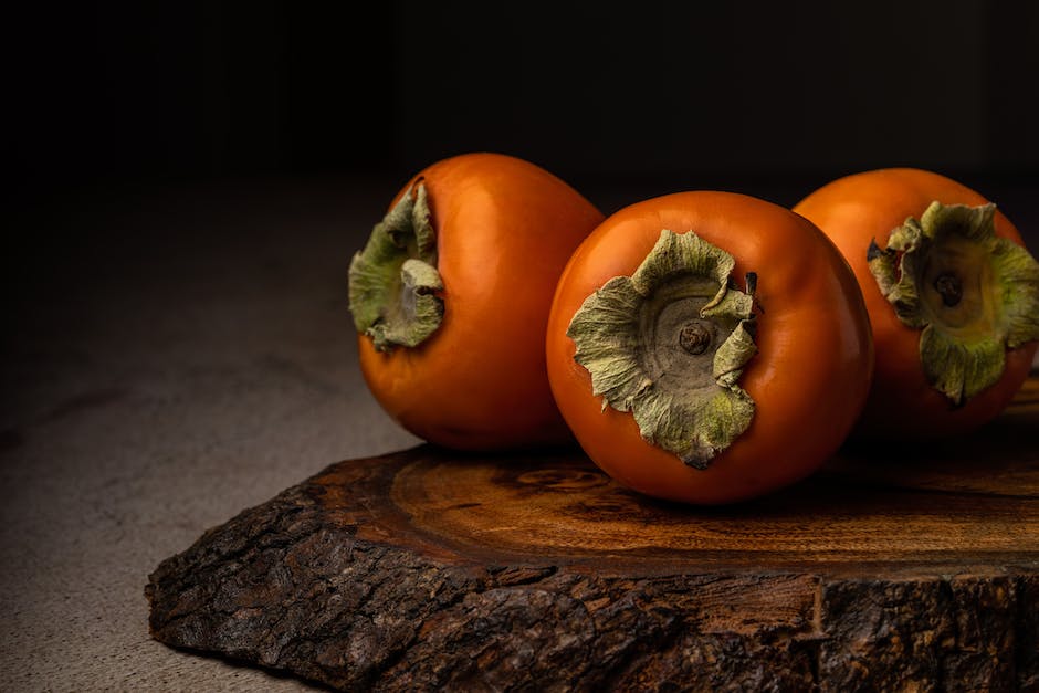 Image of a person holding different types of persimmons to choose from during persimmon picking.