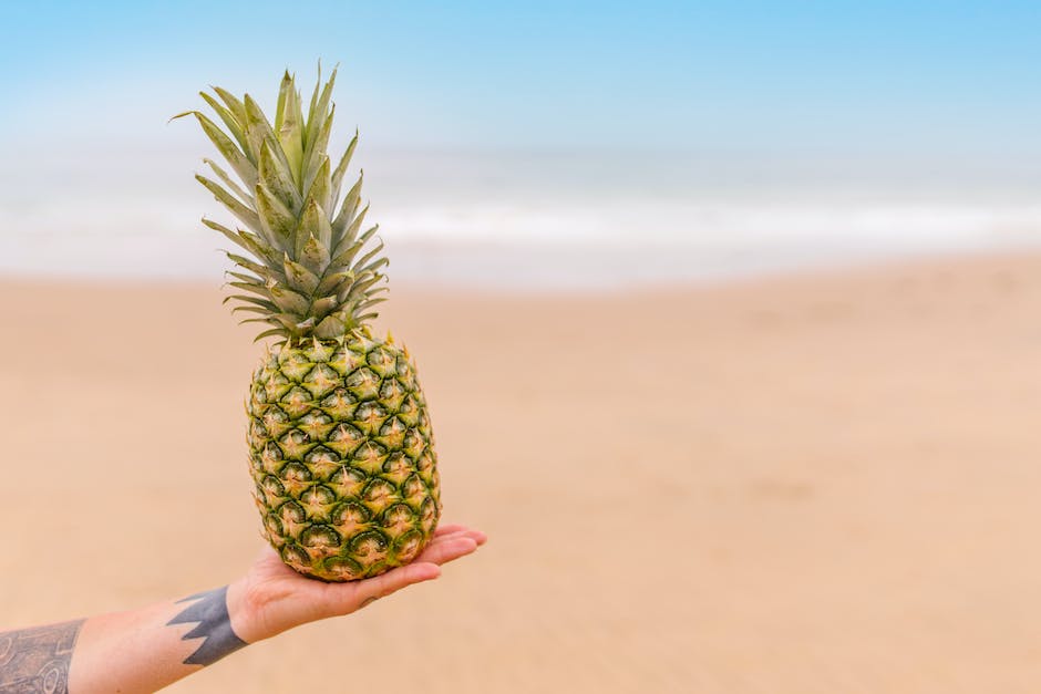 Image of a person confidently peeling a pineapple, showcasing the step-by-step process described in the text