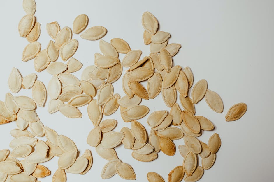 A close-up image of a handful of freshly cleaned pumpkin seeds.