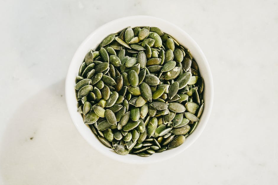 Image of pumpkin seeds in a bowl, showcasing their various shapes and colors, suitable for those visually impaired