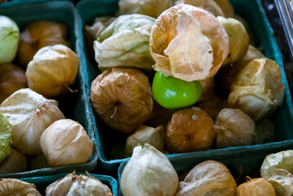 A ripe tomatillo on a wooden cutting board