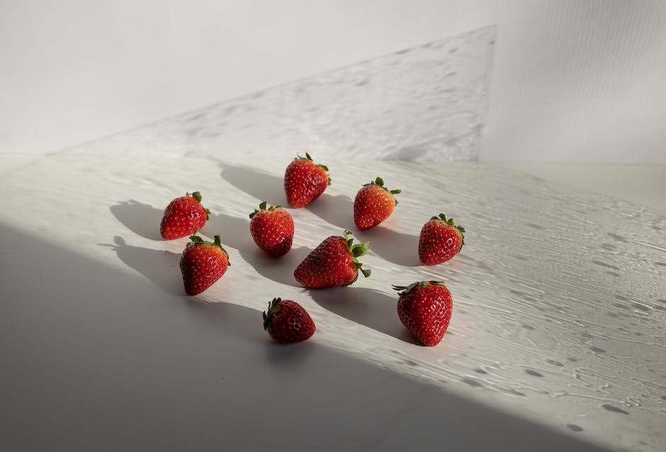 Image illustrating strawberry hydration, showing a person watering a strawberry plant with a watering can