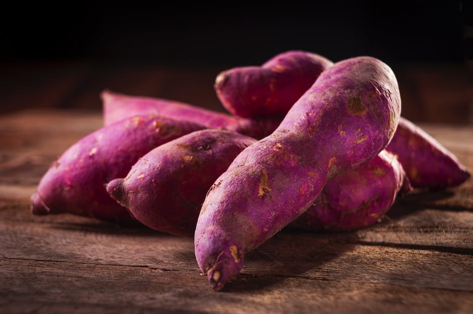 A close-up image of freshly harvested sweet potatoes, featuring various sizes and shapes.