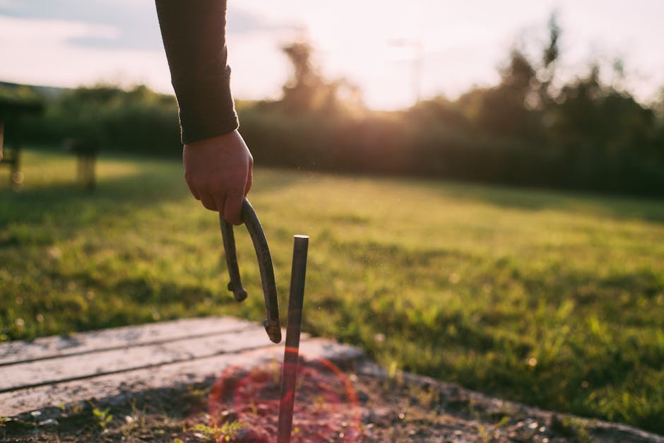 An image of a person using stakes and ties to straighten a leaning tree.